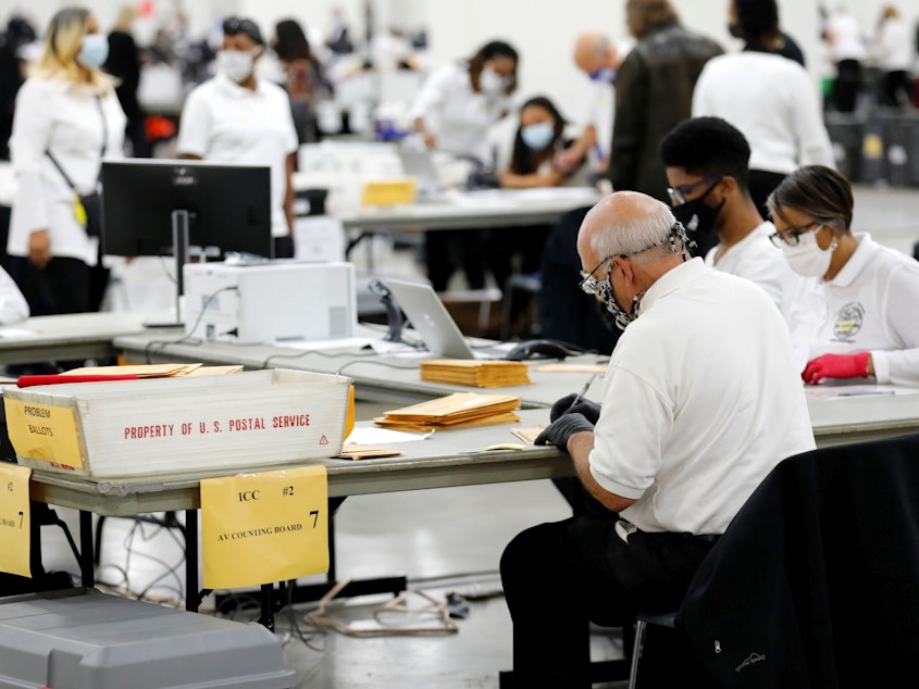 caption: Election workers count absentee ballots earlier this month in Detroit, the county seat of Wayne County, Mich.