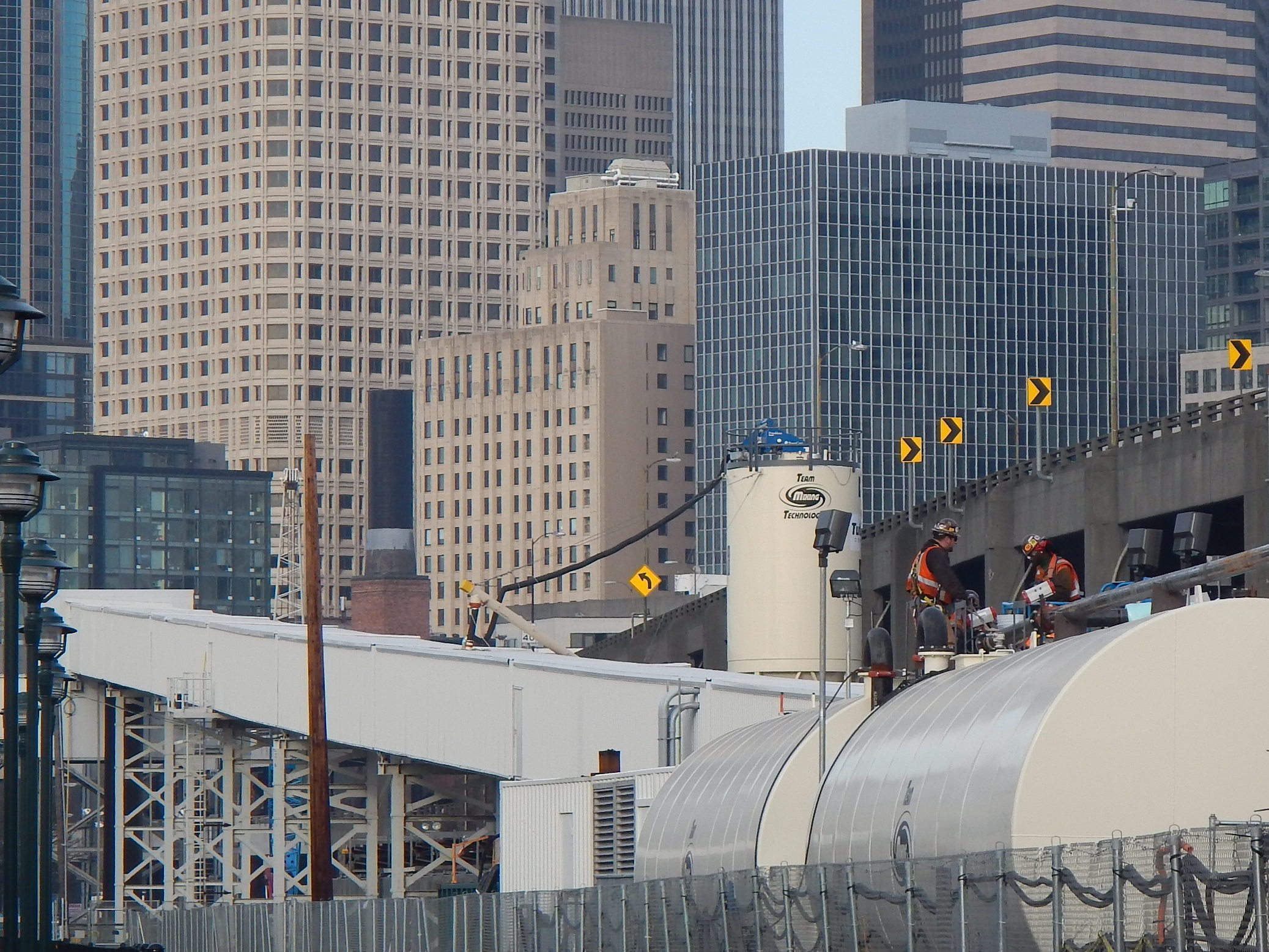caption: A Seattle Tunnel Partners crew works on one of the tanks holding soil conditioner being used to seal an underground air bubble. 