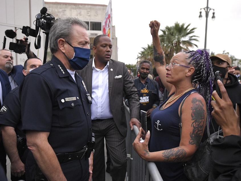 caption: Los Angeles Police Department Chief Michel Moore speaks to a protester after a vigil with members of professional associations and the interfaith community at LAPD headquarters, Friday, June 5, 2020, in Los Angeles.