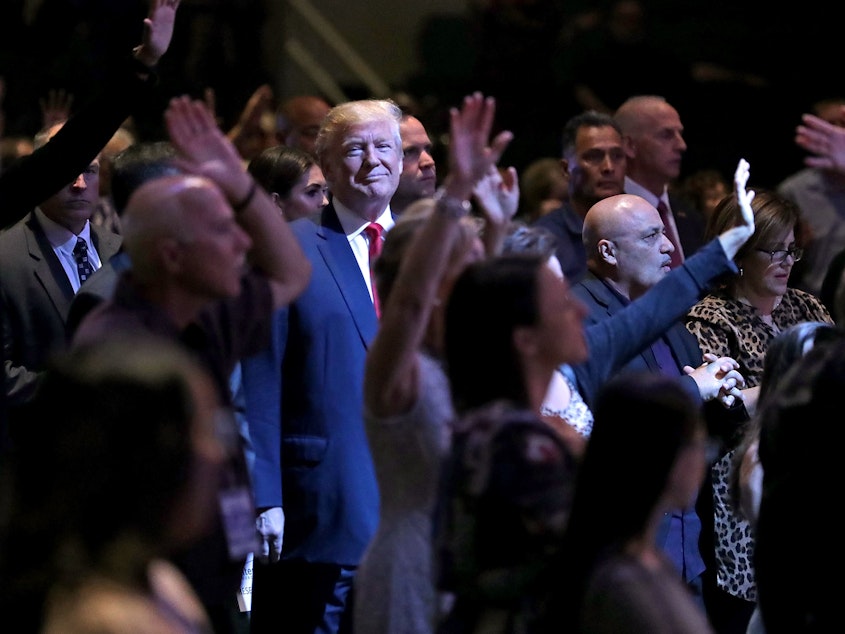 caption: Donald Trump attends a worship service in Las Vegas when he was a presidential candidate in 2016. Trump won over many white conservative Christians by wrapping their traditional priorities in with his own particular cultural fixations.