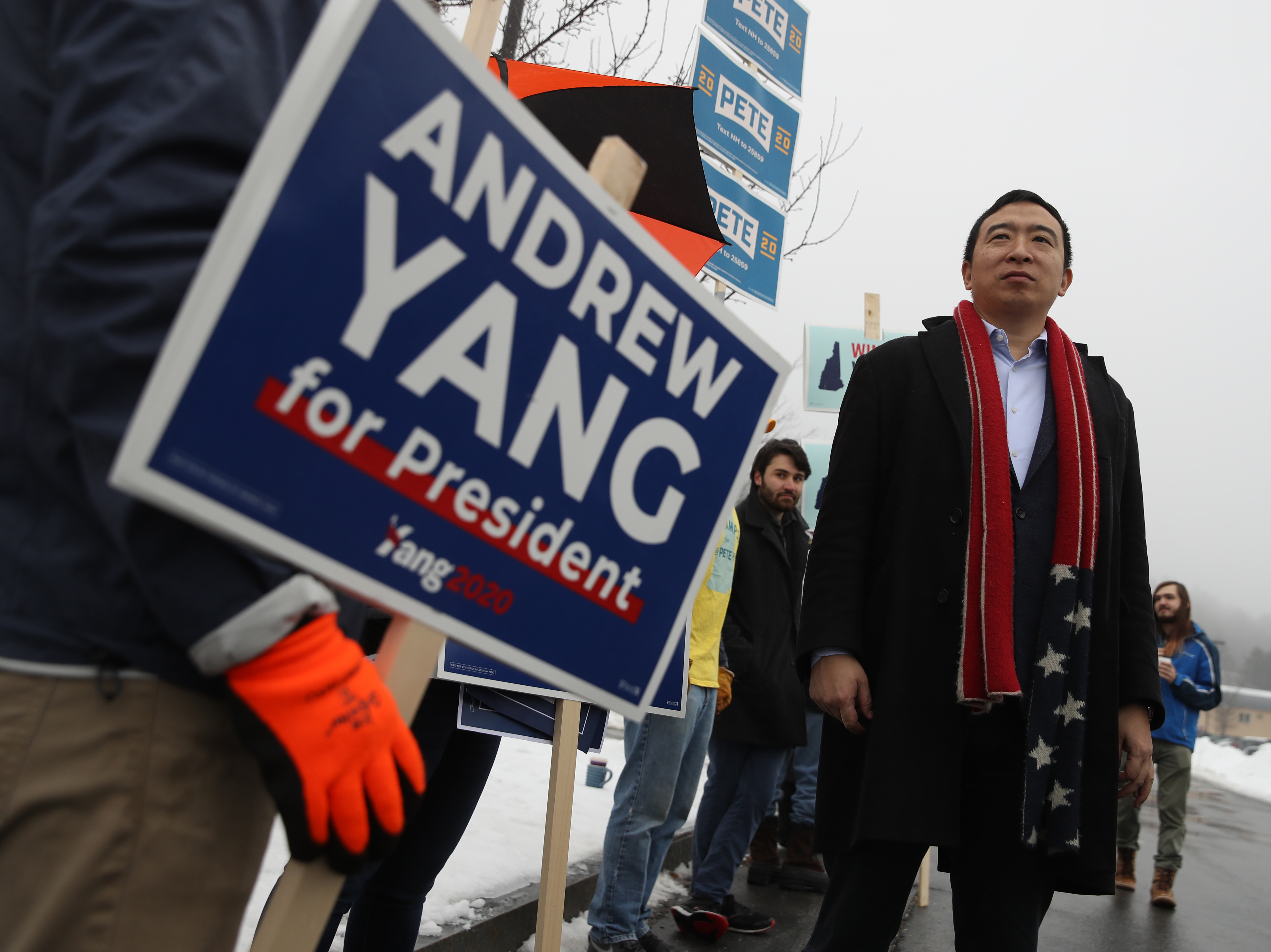 caption: Democratic presidential candidate Andrew Yang greets supporters in front of a polling station on Feb. 11 in Keene, N.H.