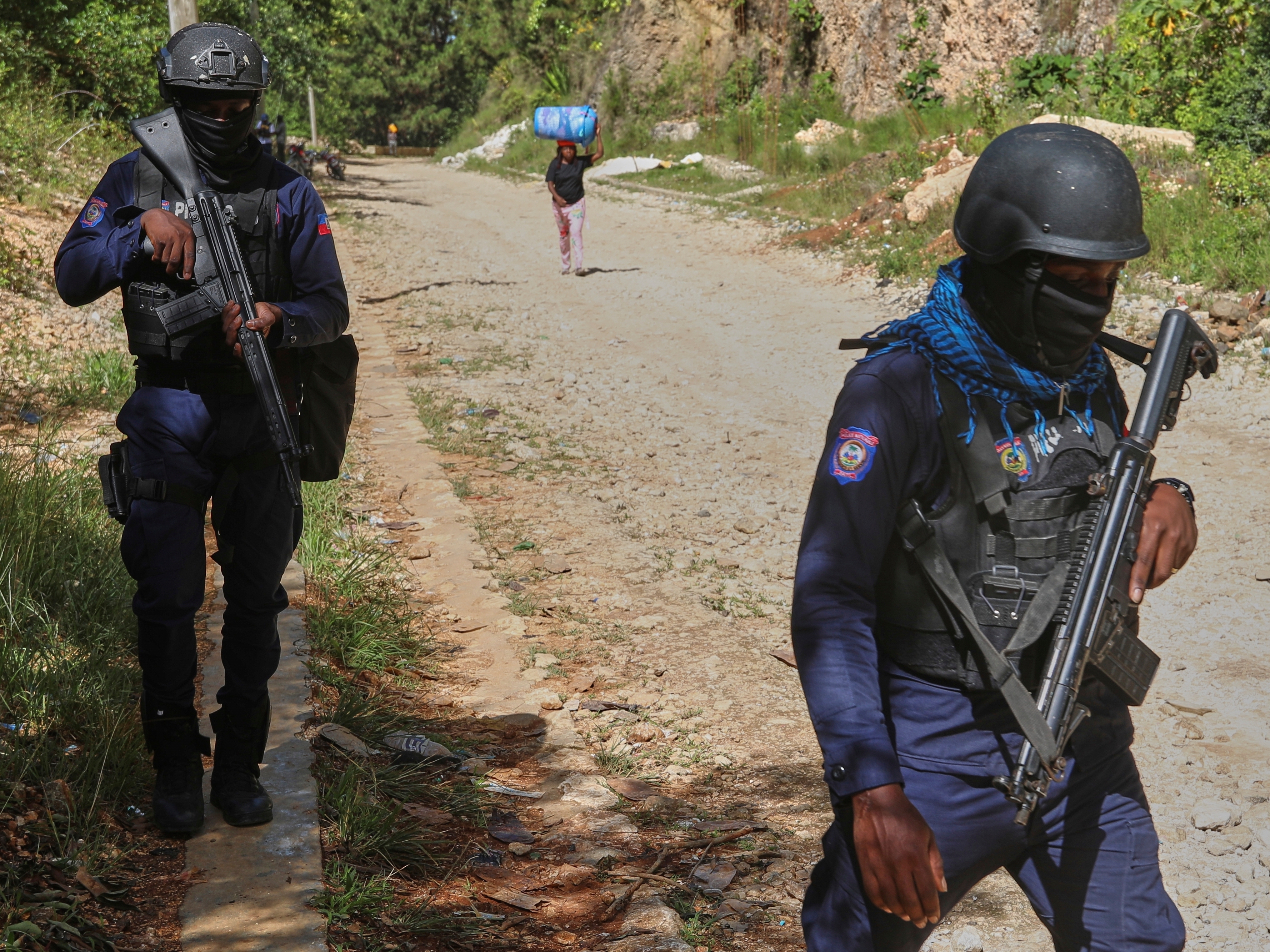 caption: Police officers patrol the area near the Saint-Helene orphanage in the Kenscoff neighborhood of Port-au-Prince, Haiti.