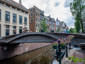 caption: The almost 40-foot 3D-printed pedestrian bridge designed by Joris Laarman and built by Dutch robotics company MX3D has been opened in Amsterdam six years after the project was launched. The bridge, which was fabricated from stainless steel rods by six-axis robotic arms equipped with welding gear, spans the Oudezijds Achterburgwal in Amsterdam's Red Light District.