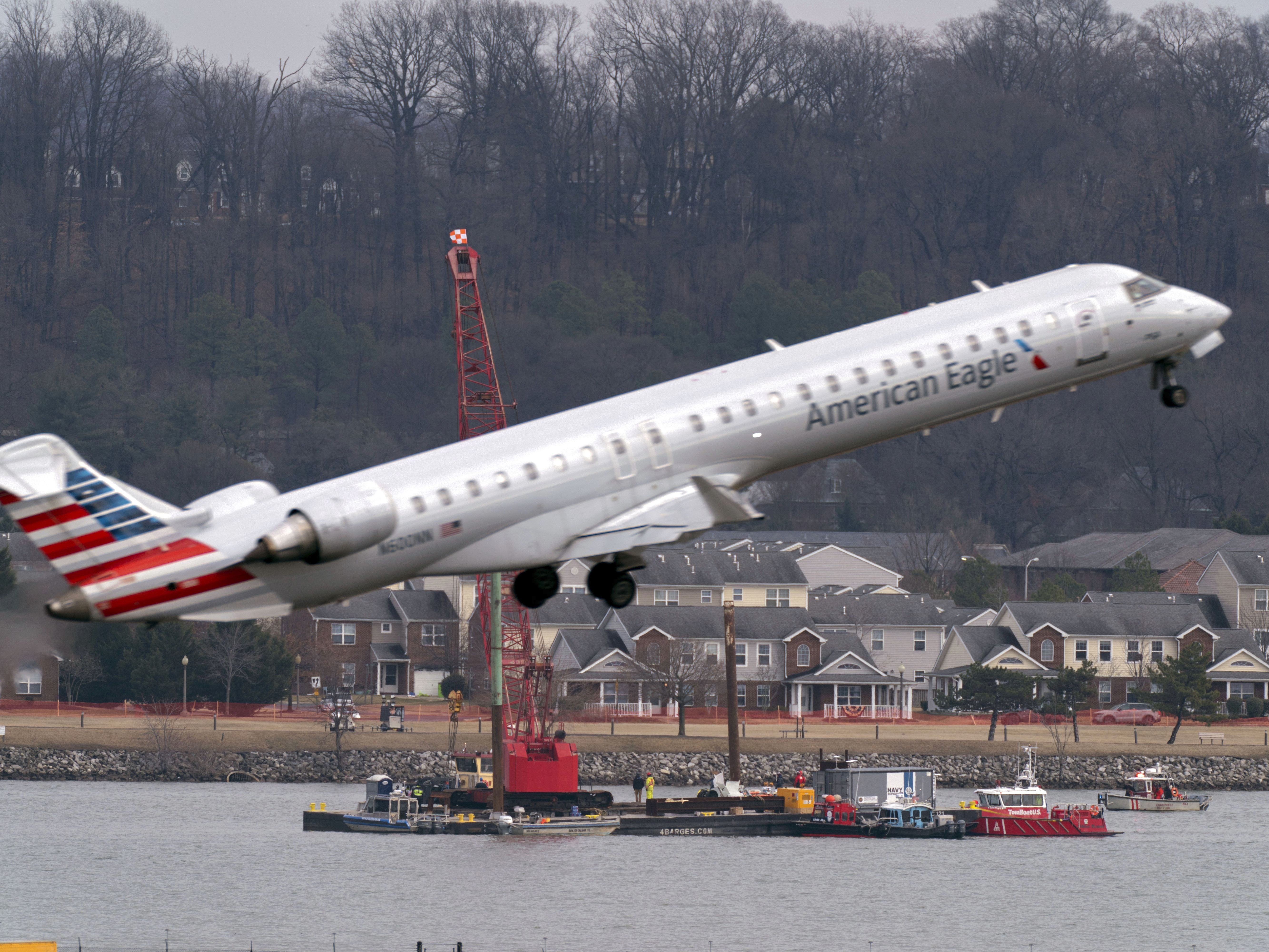 caption: Salvage crews work on recovering wreckage near the site in the Potomac River of a mid-air collision between an American Airlines jet and a Black Hawk helicopter at Ronald Reagan Washington National Airport, Feb. 6, 2025, in Arlington, Va.