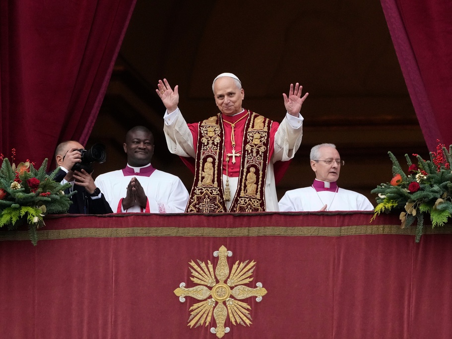 caption: Pope Leo XIV waves Thursday after delivering the Urbi et Orbi (Latin for 'to the city and to the world' ) Christmas blessing from the main balcony of St. Peter's Basilica at the Vatican.