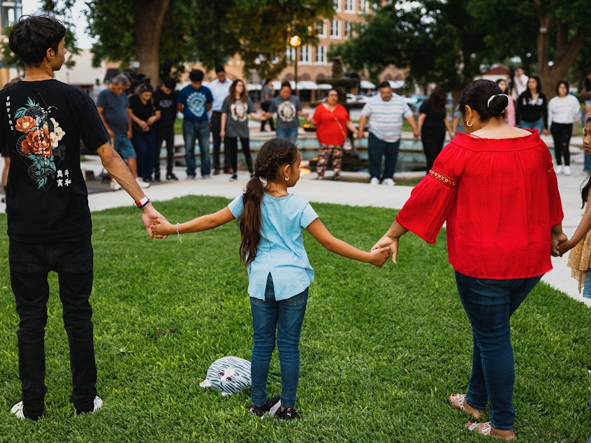 caption: Members of the community gather at the City of Uvalde Town Square for a prayer vigil in the wake of a mass shooting at Robb Elementary School on Tuesday in Uvalde, Texas.