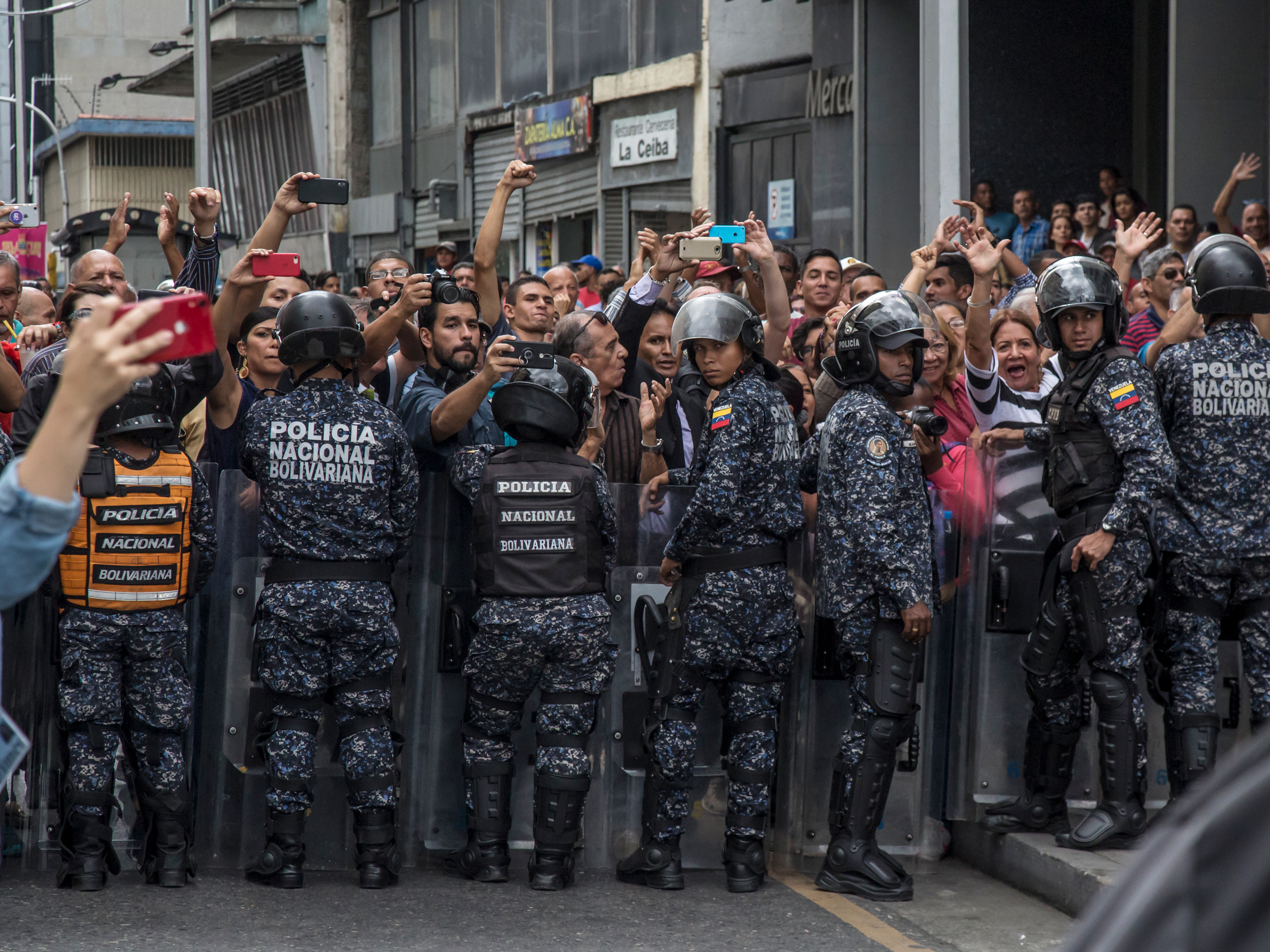caption: Juan Guaidó, accompanied by legislators of the opposition parties, fights a military blockade to the National Assembly in January in Caracas. Guaidó and opposition legislators were prevented from joining the sessions.