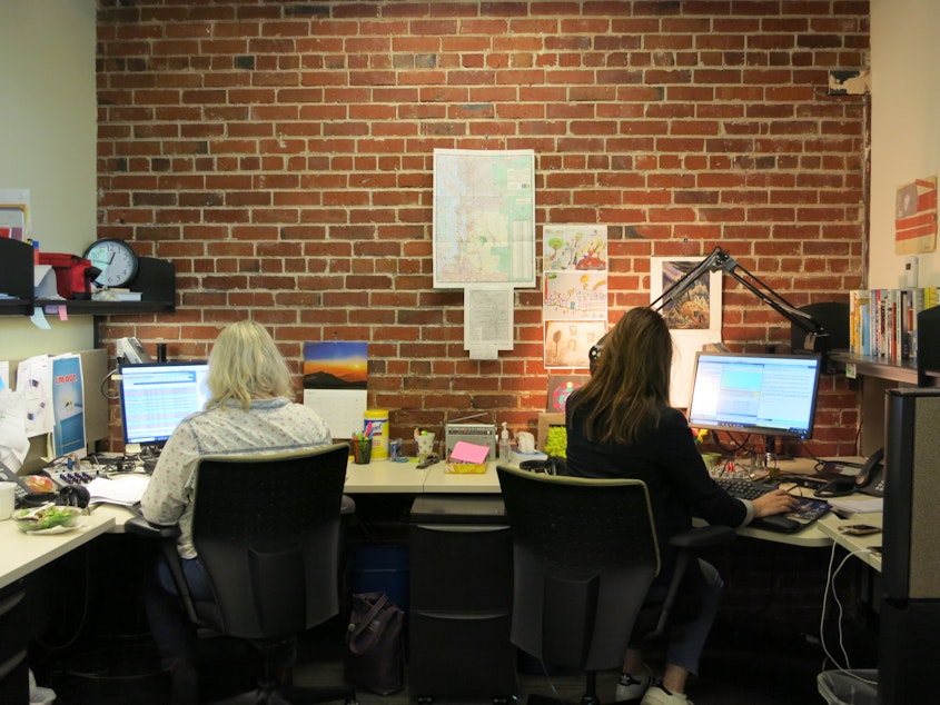 caption: In the KUOW newsroom, board operator Tami Kosch (r) and All Things Considered host Kim Malcolm work in front of an unreinforced masonry wall. (Don't worry, it's been retrofitted.)