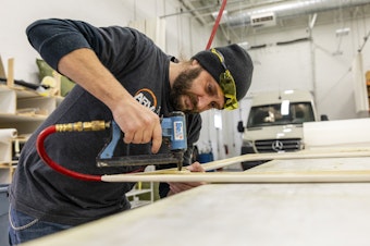 caption: Bill Kowalcic works on wall panels in the finishing department at Advanced RV. After the company went to a four-day workweek, his team figured out how to cut time without cutting corners.