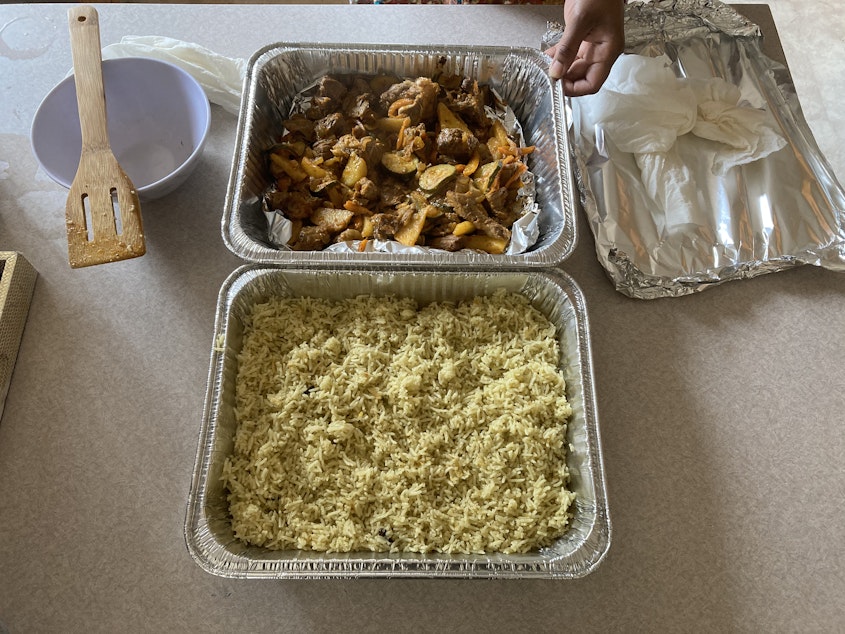 caption: My mom, Mulki Mohamed, calls out each of my siblings' names to tell them the food is ready as she sets out the rice and meat. The produce and stuff that I buy from the grocery store is used everyday in the kitchen. My worry and fear of exposing my siblings and mom to the virus from just coming back from the grocery store disappears.