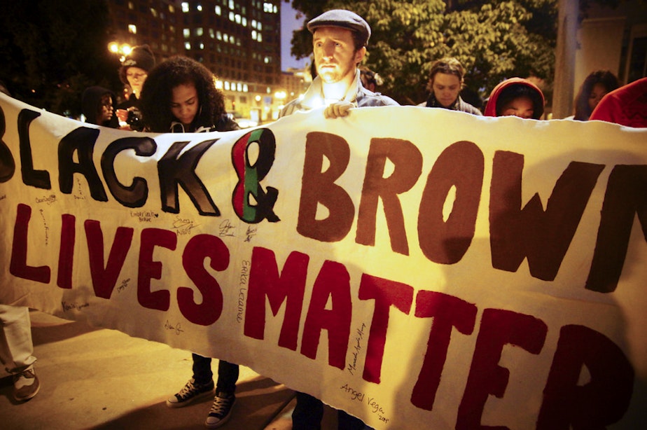 caption: People take part in a 'Black Lives Matter' demonstration.