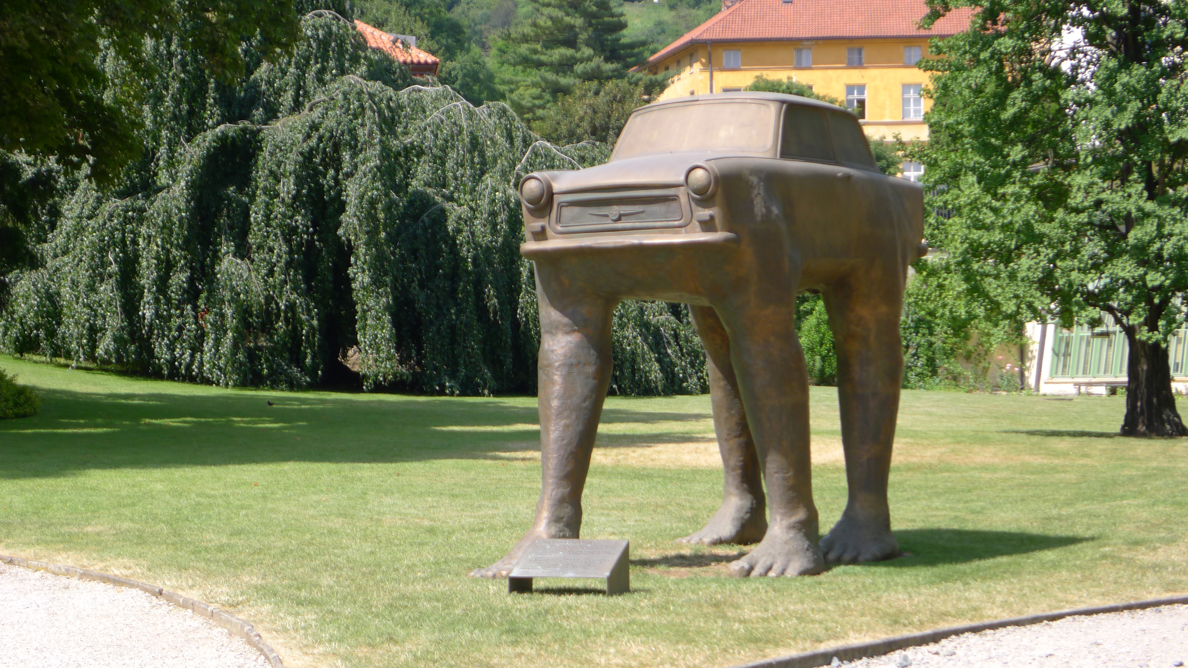 caption: David Cerny's sculpture "Quo Vadis" on the grounds of the German embassy in Prague. It commemorates the East Germans who came here to seeking asylum. The car is an East German-made Trabant. Many asylum seekers abandoned them on the streets.