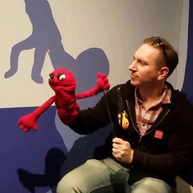 caption: Anthonio Pettit at a Muppet exhibit at MOPOP. As a writer for AIs, Pettit is also a sort of smart speaker puppetmaster.