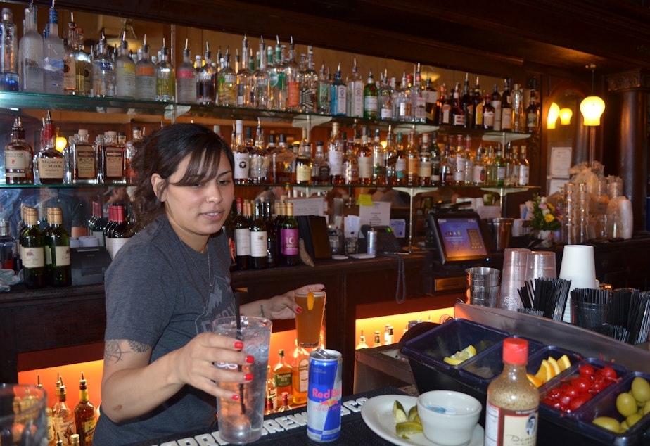 caption: Rita Rosa works at her newly reopened bar at the Rainier Bar and Grill in Enumclaw.