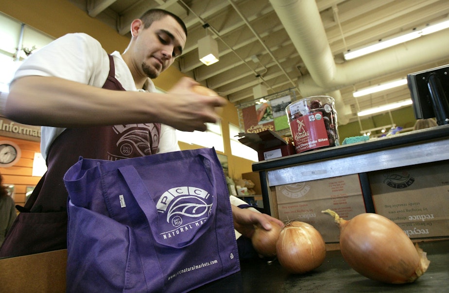 caption: Isaiah McDaniel bags groceries into a customer's cloth bags at PCC Natural Market Tuesday, Jan. 15, 2008, in Seattle. 