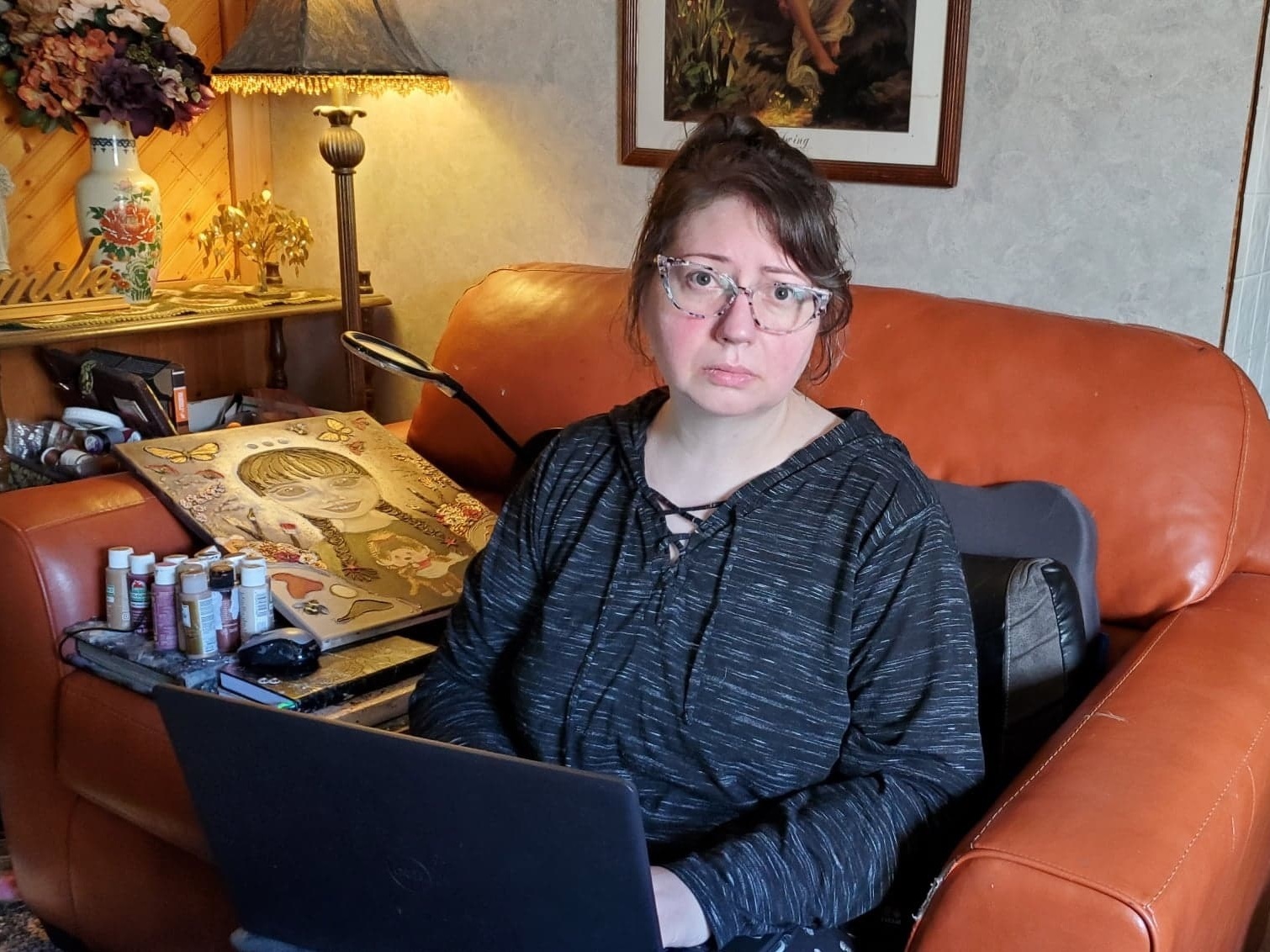 caption: Georgia Linders got sick with COVID in the spring of 2020 and never recovered. Her ongoing battle with long COVID has prevented her from working. She spends her days advocating for COVID longhaulers like herself and painting, one of the few activities that doesn't wear her out.