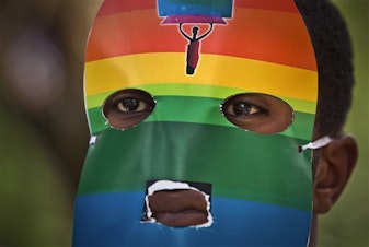 caption: In this Feb. 10, 2014, file photo, a Kenyan gay wears a mask to preserve his anonymity during a rare protest against Uganda's anti-homosexuality law.