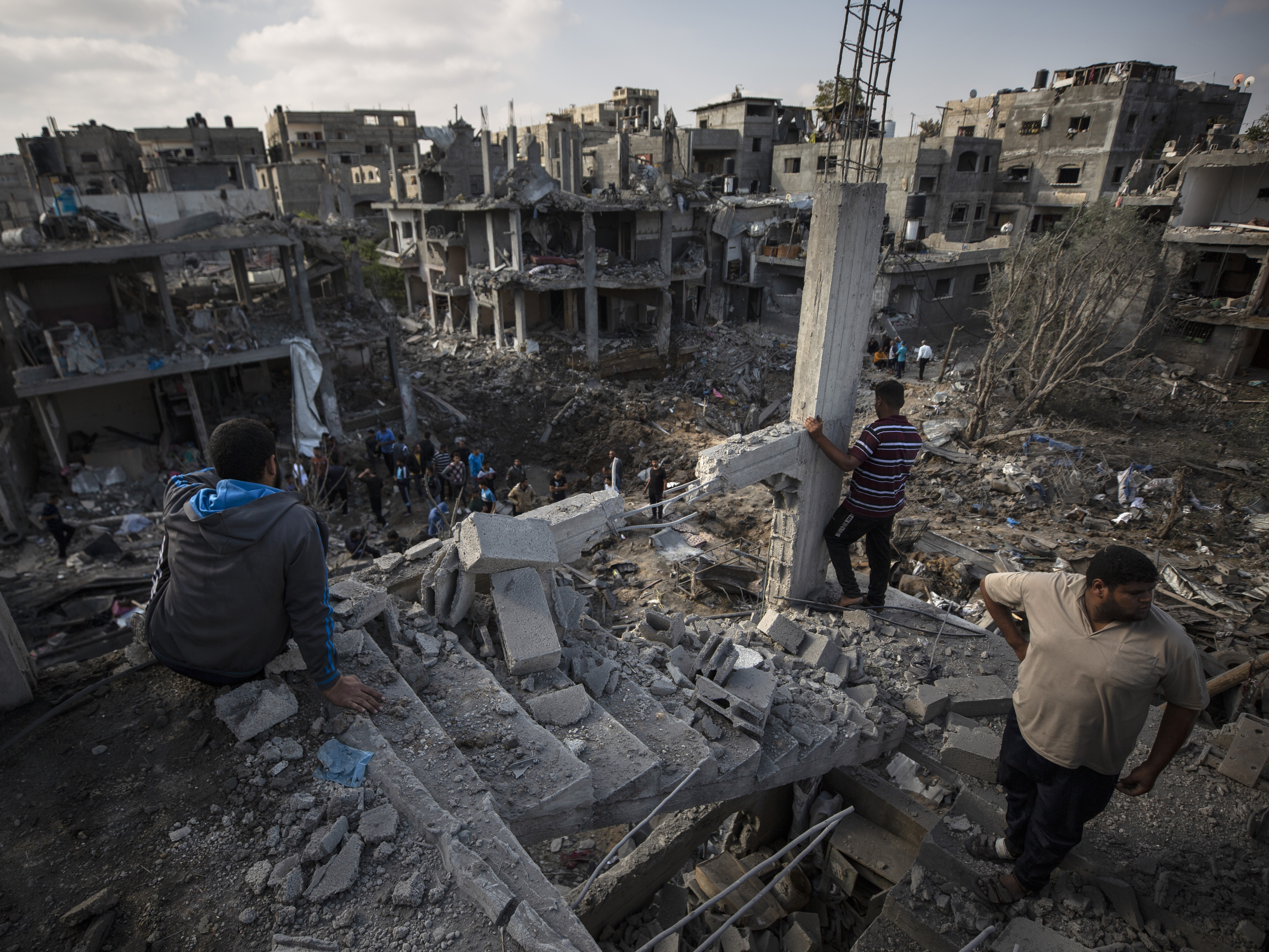 caption: Palestinians inspect their destroyed houses Friday following overnight Israeli airstrikes in Beit Hanoun in the northern Gaza Strip.