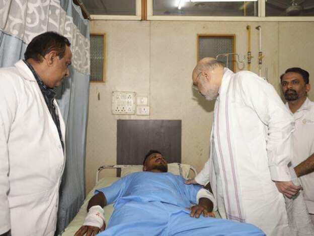 caption: Viswashkumar Ramesh, the sole survivor of Thursday's Air India crash, meets with Home Affairs Minister Amit Shah at a hospital in Ahmedabad.