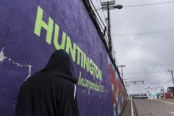 caption: A pedestrian walks past a mural in Huntington, W.Va., on March 18. Huntington was once ground zero for the U.S. opioid epidemic.