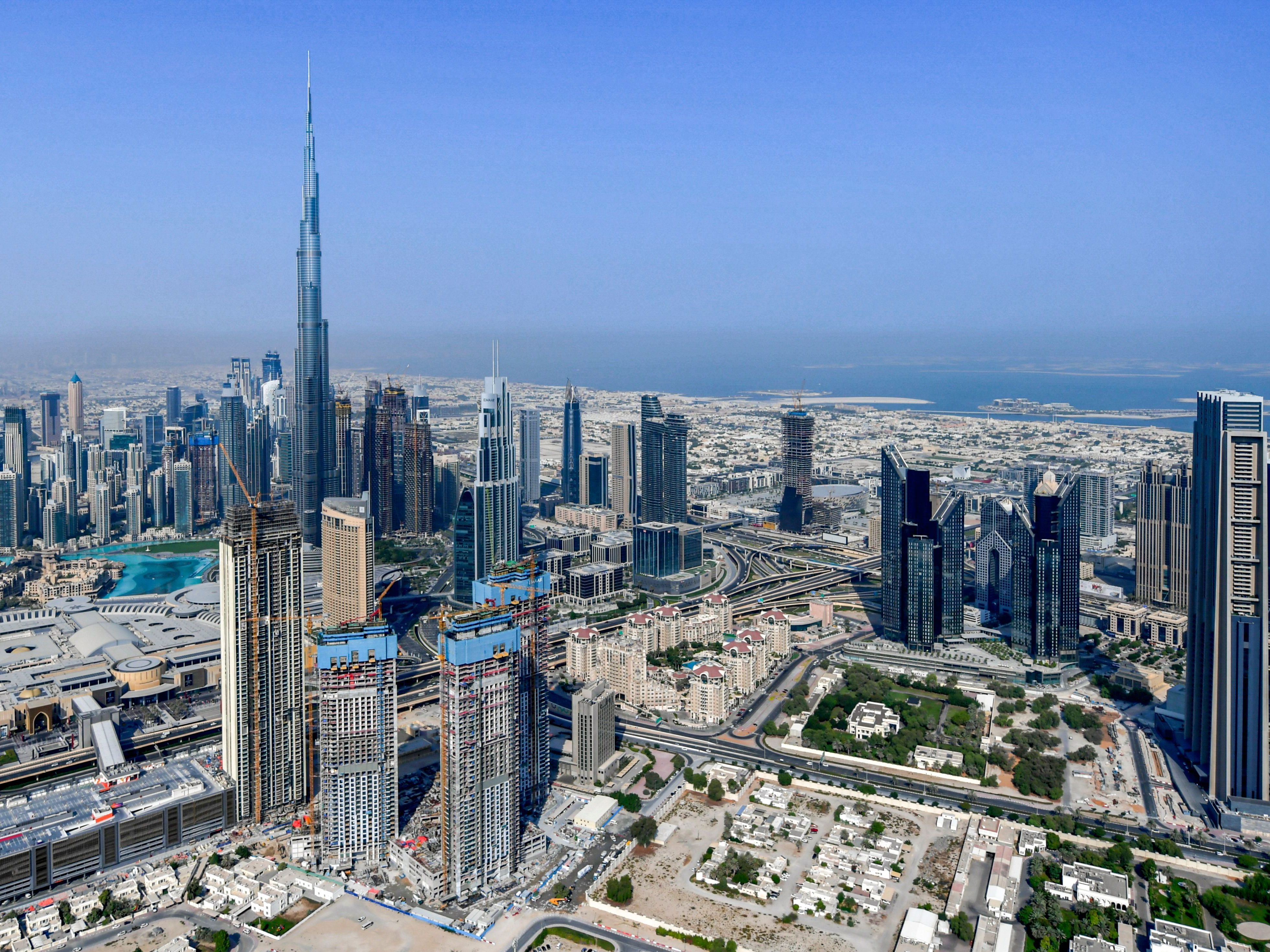 caption: The United Arab Emirates is changing its workweek to have half days on Fridays and a Saturday-Sunday weekend. Here, the country's emirate of Dubai and its Burj Khalifa skyscraper are photographed from a helicopter on July 8, 2020.