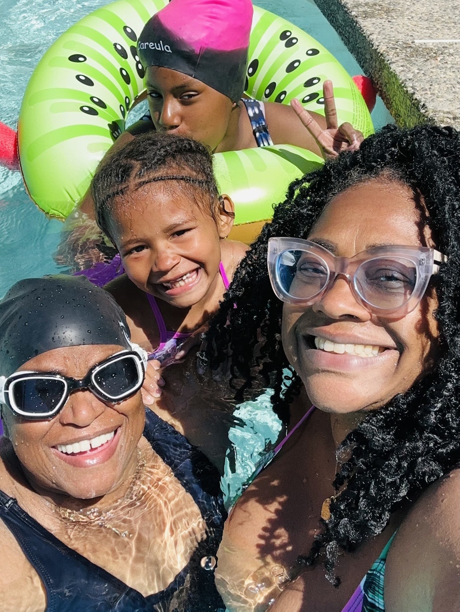 caption: Aaliyah Messiah (far left), Najmah Messiah (far right), Taniya Guster (back), and Taniya’s little sister Ashani (middle) swim in a pool during a recent vacation in Wenatchee, Washington.