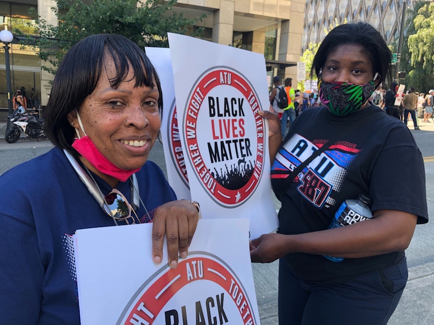 caption: Mechelle Penny and a fellow bus driver at a protest over racism and labor issues at King County Metro