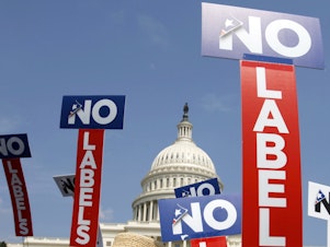 caption: People with the group No Labels hold signs during a rally on Capitol Hill in Washington, D.C., on July 18, 2011.