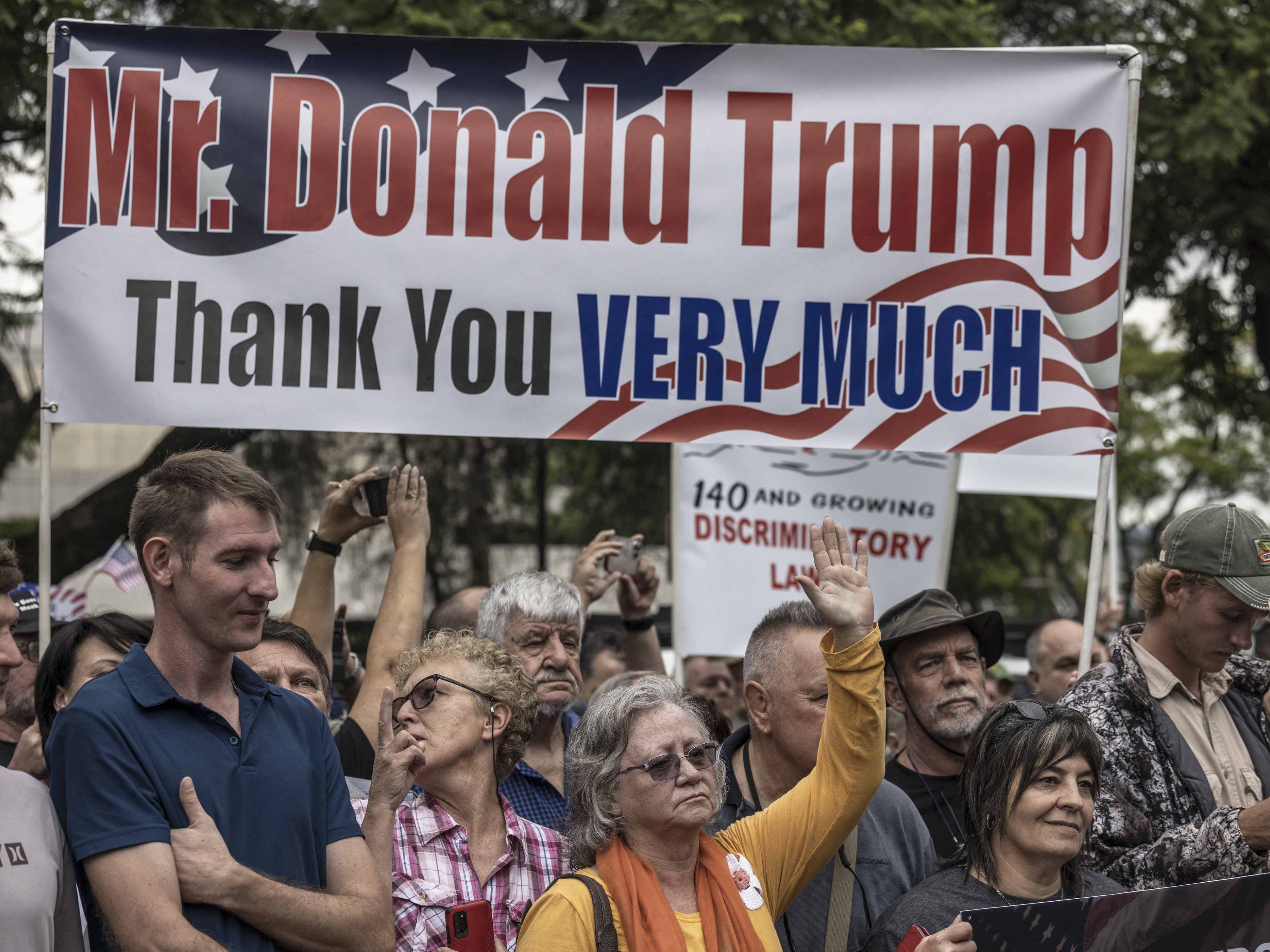 caption: Afrikaan South Africans supporting US President Donald Trump and South African and US tech billionaire Elon Musk gather in front of the US Embassy in Pretoria, on February 15, 2025 for a demonstration.