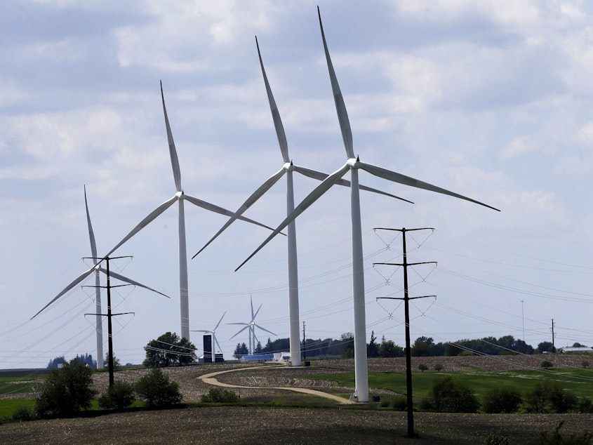 caption: Wind turbines in a field in Adair, Iowa. Democrats' budget deal would use financial carrots and sticks to encourage utilities to shift to clean energy.