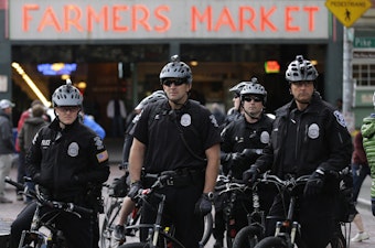 caption: FILE: Seattle Police officers on bicycles wait in a group while monitoring a protest against shootings of unarmed civilians by police, Tuesday, April 14, 2015, in Seattle. 