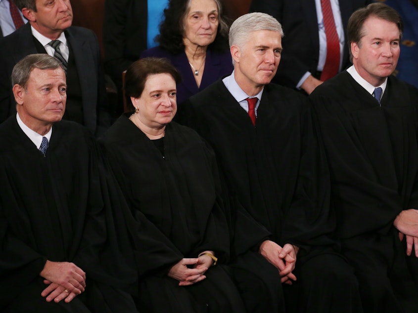 caption: Supreme Court Justices (from left) John Roberts, Elena Kagan, Neil Gorsuch and Brett Kavanaugh attend the State of the Union address on Feb. 4, 2020. In her confirmation hearing, Judge Amy Coney Barrett explained the tradition of judges wearing black robes.
