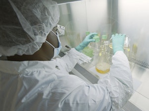 caption: An Eli Lilly researcher tests possible COVID-19 antibodies in a laboratory in Indianapolis.