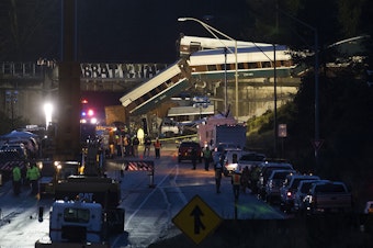 caption: The scene of an Amtrak derailment over Interstate 5 taken in the evening on Monday, December 18, 2017 from Mounts Road.