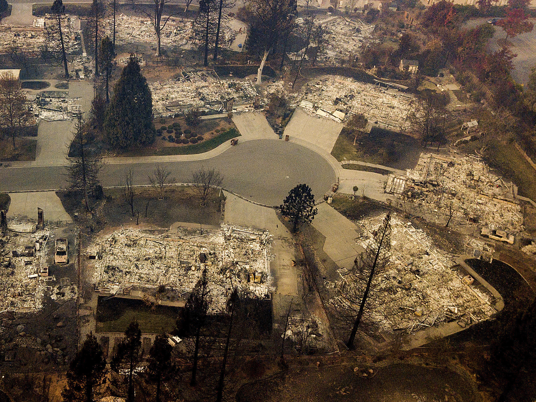 caption: Residences leveled by the Camp Fire line a cul-de-sac in Paradise, Calif., earlier this month. A massive federal report says climate change is contributing to larger wildfires as well as other deadly extreme weather.