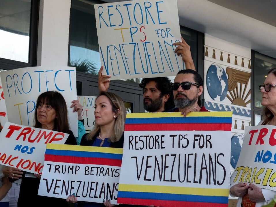 caption: Laura Kelley, Miami-Dade County Democratic Party chair, (second from the left) joins others to support a resolution in favor of reinstating temporary protected status for Venezuelans in February in Miami.