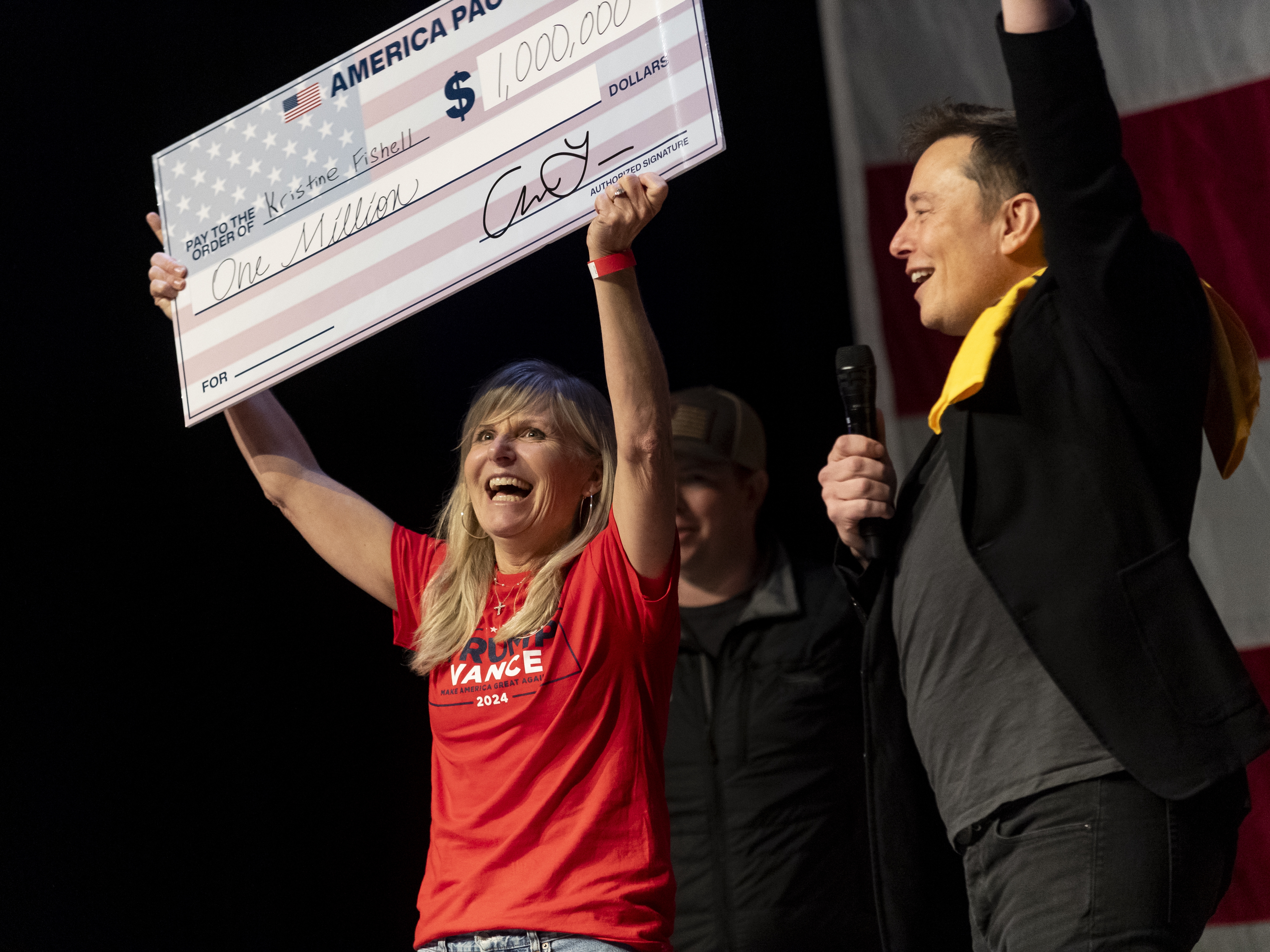 caption: SpaceX and Tesla founder Elon Musk awarded Kristine Fishell with a $1 million check on Oct. 20. The legality of these cash prizes has been called into question.