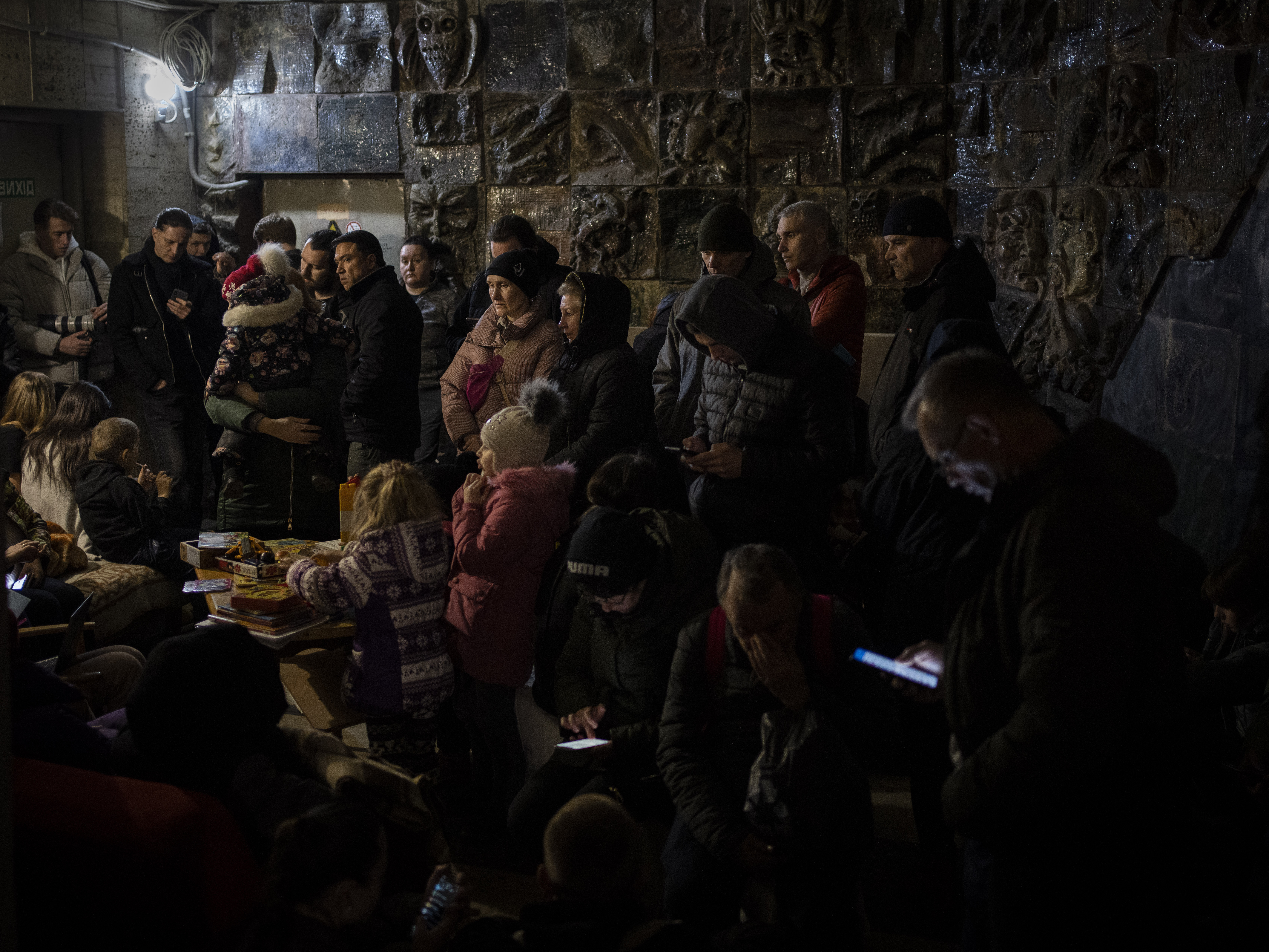 caption: <strong>March 19: </strong>People gather in a basement, used as a bomb shelter, during an air raid in Lviv, Western Ukraine.