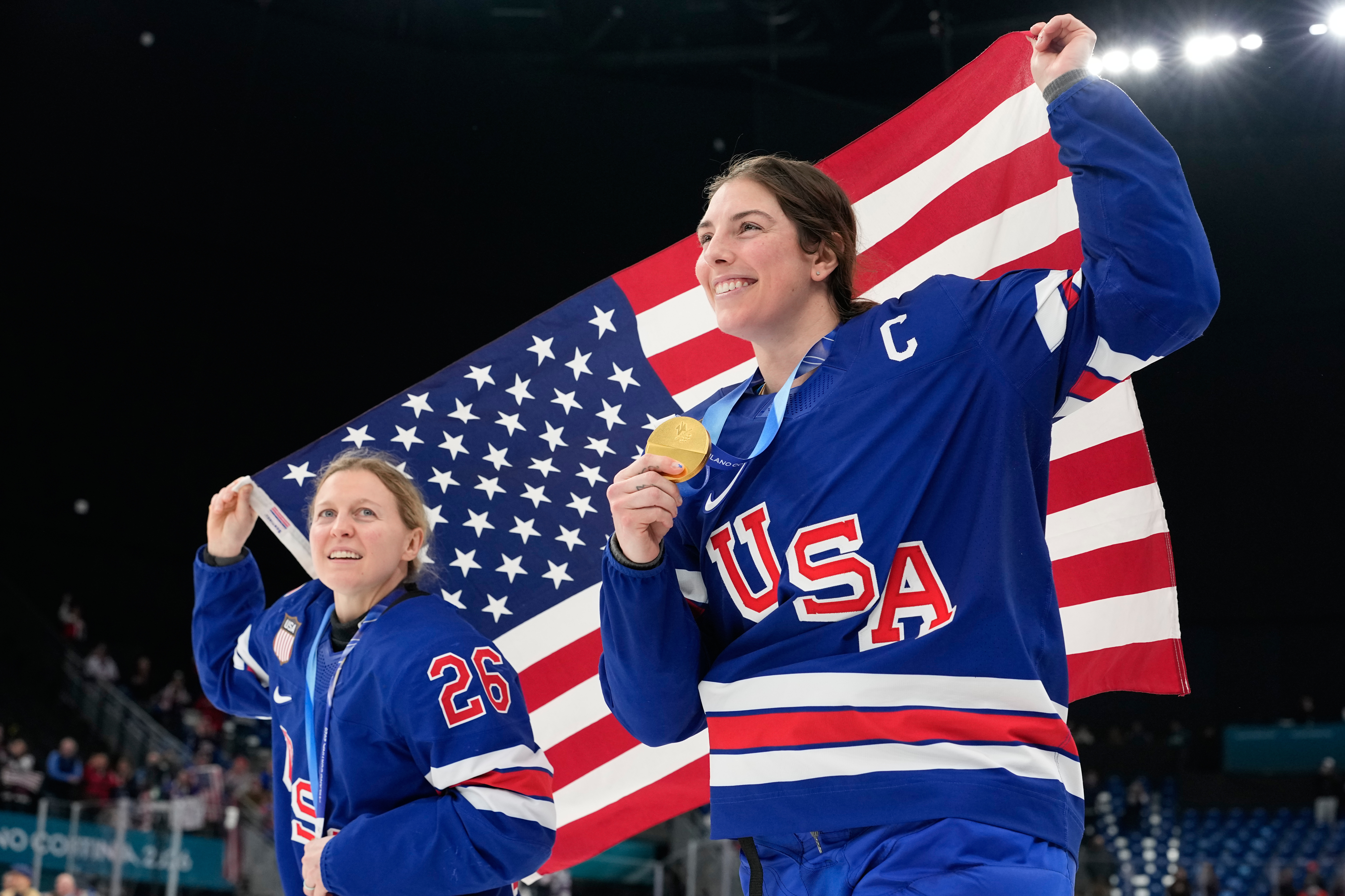 caption: United States' Kendall Coyne, left, and United States' Hilary Knight celebrate after victory ceremony for women's ice hockey at the 2026 Winter Olympics, in Milan, Italy, Thursday, Feb. 19, 2026. 