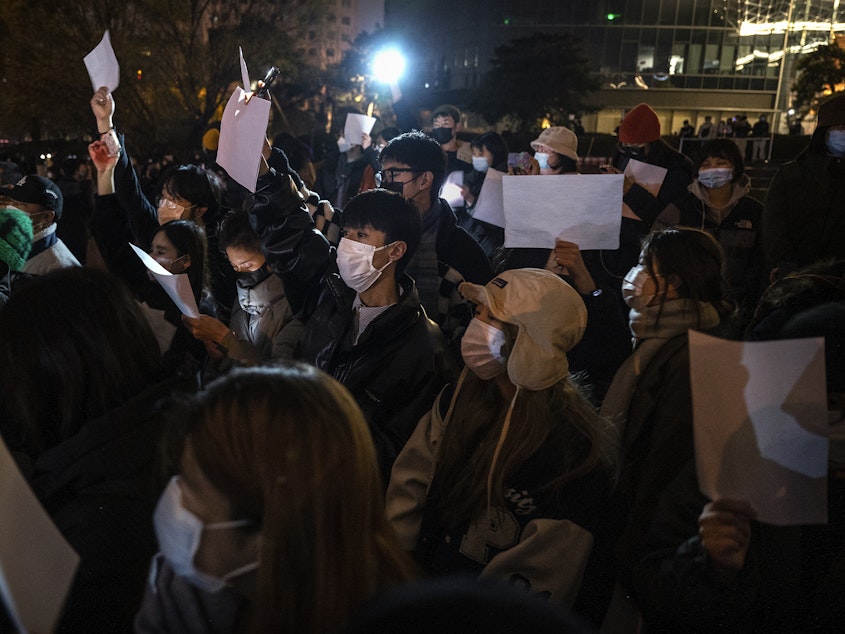 caption: Protesters hold up a white piece of paper against censorship during a protest against China's strict zero COVID measures on November 27, 2022 in Beijing.