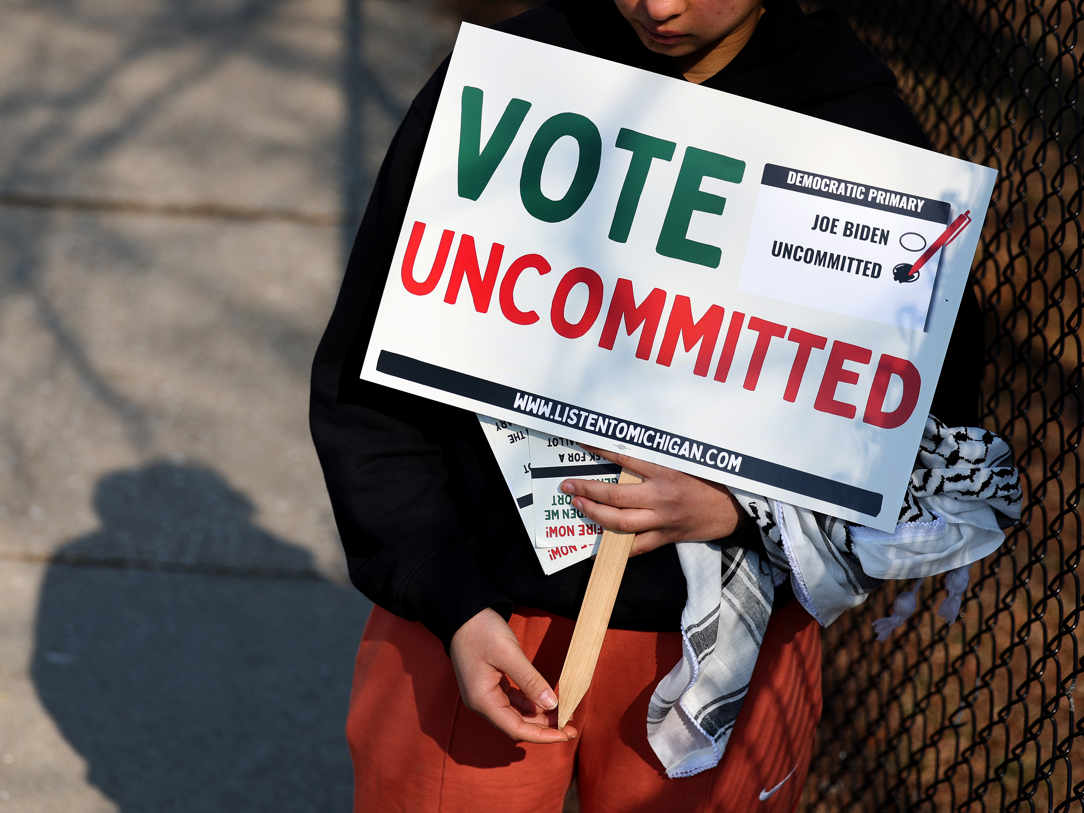caption: A Democratic voter uncommitted to President Biden rallies outside of a polling location at Maples Elementary School on Feb. 27 in Dearborn, Mich.
