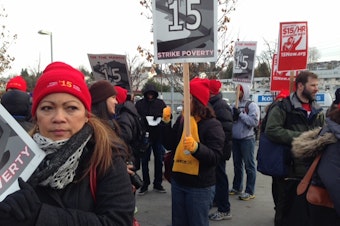 caption: Fast food workers and minimum wage advocates marched from SeaTac to Seattle as part of a national demonstration for a $15 minimum wage on December 5, 2013.
