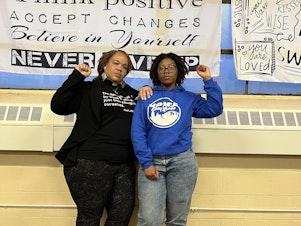 caption: Rev. Denise O. Walden-Glenn and Alia Williams each raise a fist— a symbol of solidarity and Black power— at the VOICE office in Buffalo, New York.