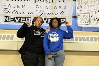 caption: Rev. Denise O. Walden-Glenn and Alia Williams each raise a fist— a symbol of solidarity and Black power— at the VOICE office in Buffalo, New York.