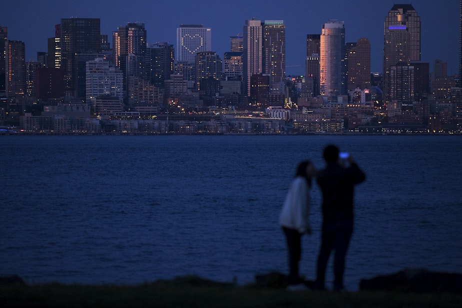 caption: Lit up windows making the shape of a heart at the Hyatt Regency are visible from Sea Crest Park along Harbor Avenue Southwest on Wednesday, April 8, 2020, in Seattle. As of Friday, April 10, the Washington State Department of Health had reported 491 Covid-19 related deaths.
 