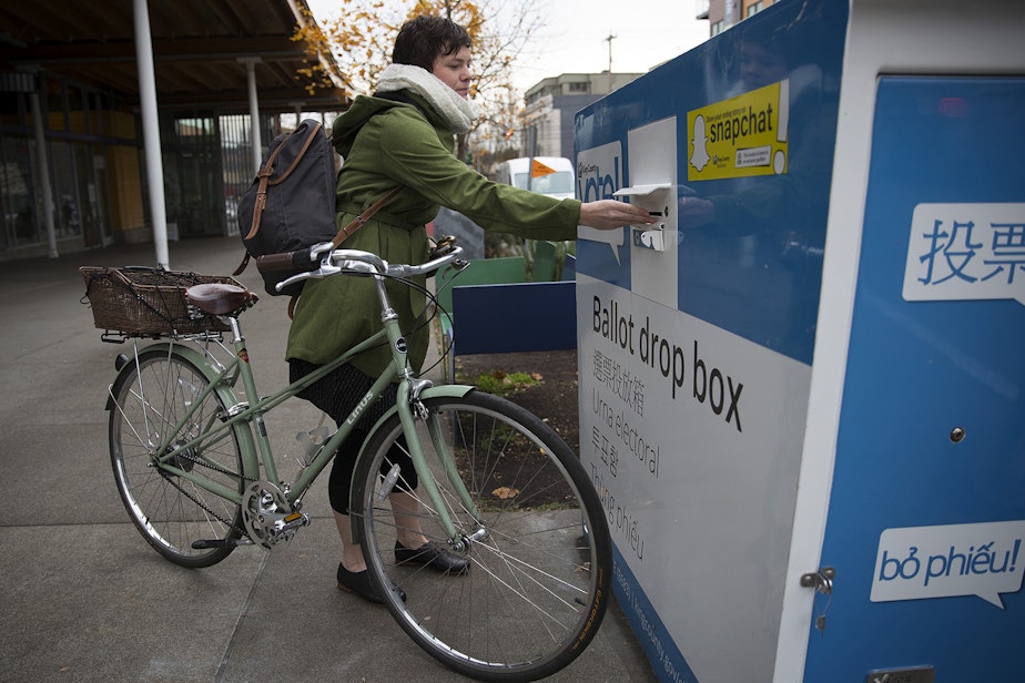caption: FILE: Siri Anderson drops her ballot into the ballot drop box outside of the Seattle Public Library on Tuesday, November 7, 2017, in Ballard. 