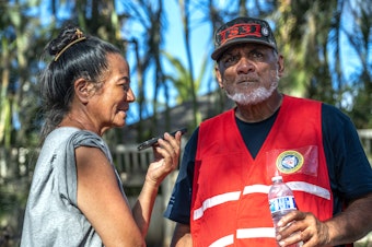 caption: Uilani (left) and Keeamoku Kapu run the Na 'Aikane o Maui Cultural and Research Center which was burned to the ground in the wildfires so they set up this grassroots community distribution center in Lahaina. They are on the phone here taking a call from Oprah about supplies she will be delivering.
