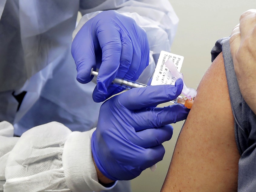 caption: The second patient in a first-stage study of a potential vaccine for COVID-19 receives a shot in in March at the Kaiser Permanente Washington Health Research Institute in Seattle.