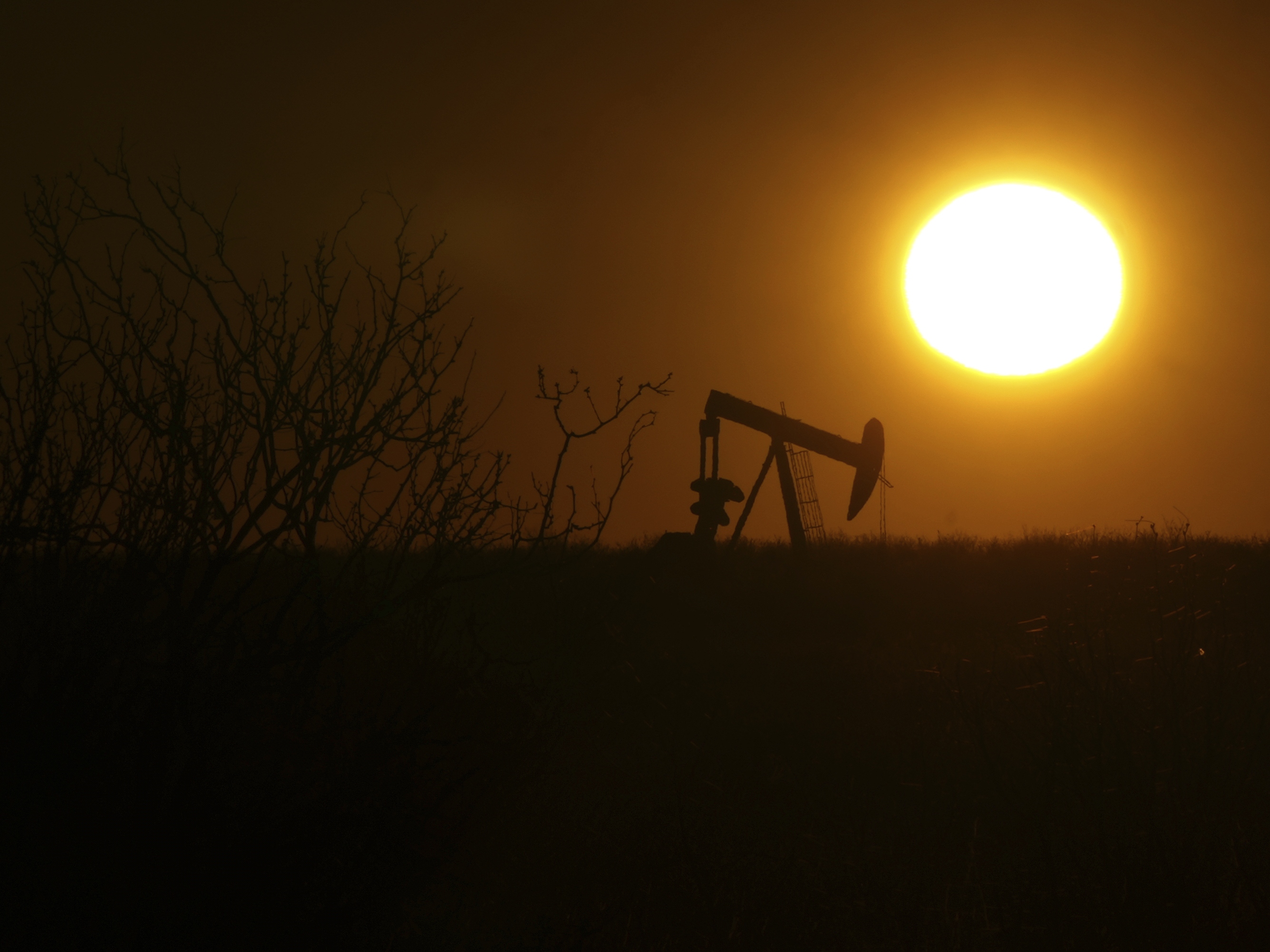caption: A pumping jack is visible at sunrise on Feb. 24, 2025, in Hobbs, New Mexico.