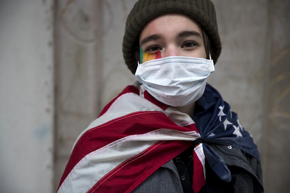 caption: Chloe Fierstein, 14, stands for a portrait while walking to the 'Our Work Continues: Protect Every Person' event, shortly after Joe Biden was officially named president-elect on Saturday, November 7, 2020, at the intersection of 10th Avenue and East Pine Street in Seattle. "Today means a lot to me," said Chloe. "We can change the harsh ways that America is right now." 